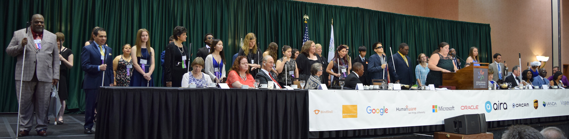 A group of scholarship winners stand on stage